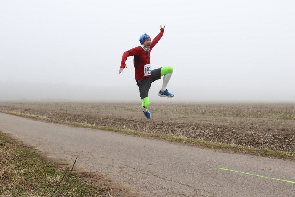  vor Glück lachender hüpfender Läufer beim 50 km Ultramarathon des Rodgau-Lauftreffs